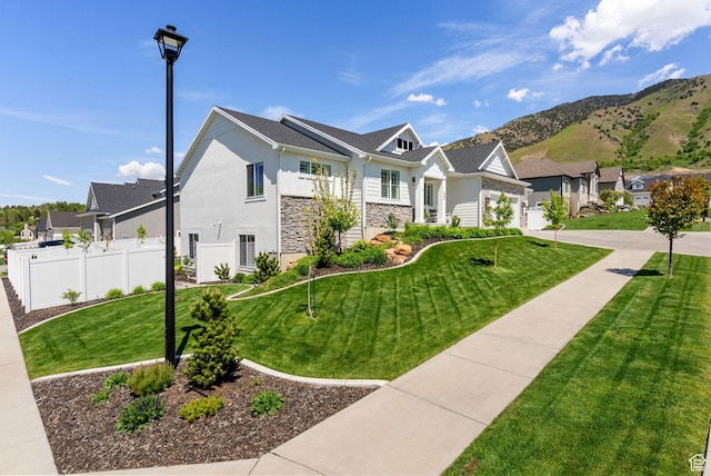 view of front facade with stone siding, a residential view, stucco siding, and a mountain view