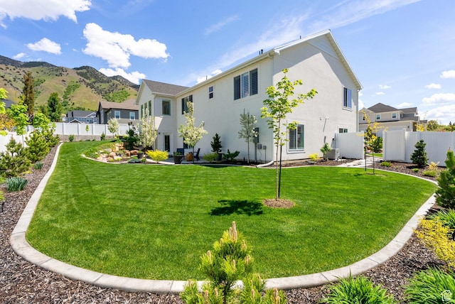 rear view of house with stucco siding and a mountain view