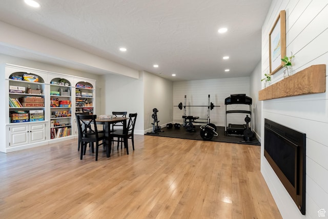 workout room with light wood finished floors, recessed lighting, and baseboards