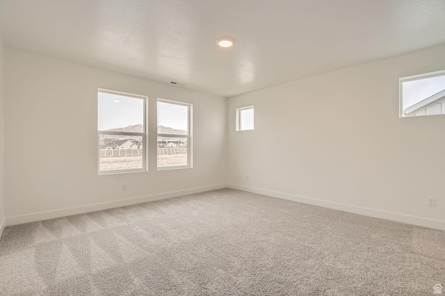 spare room featuring baseboards, light carpet, and recessed lighting