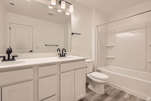full bath featuring wood finished floors, toilet, double vanity, and shower / washtub combination