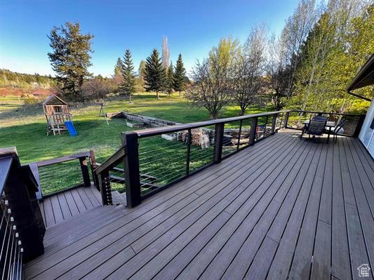 1204 Nashua Cir, Soda Springs, ID 83276 - wooden deck featuring a playground and a lawn