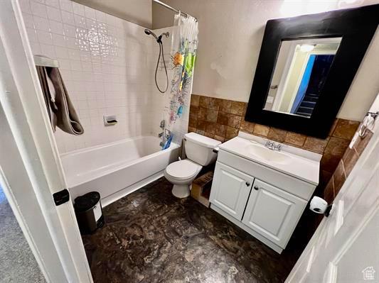 1204 Nashua Cir, Soda Springs, ID 83276 - bathroom featuring tile walls, toilet, shower / bath combination with curtain, vanity, and wainscoting