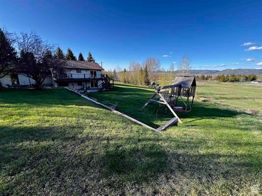 1204 Nashua Cir, Soda Springs, ID 83276 - view of grassy yard featuring a deck and a playground