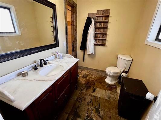 1204 Nashua Cir, Soda Springs, ID 83276 - bathroom with stone finish floors, vanity, toilet, and baseboards