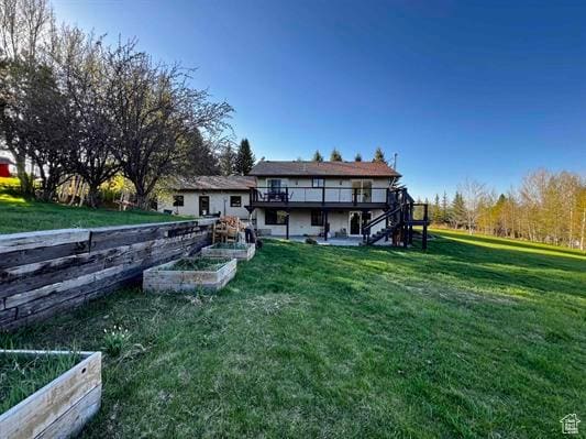 1204 Nashua Cir, Soda Springs, ID 83276 - rear view of house with a garden, a deck, stairway, and a lawn