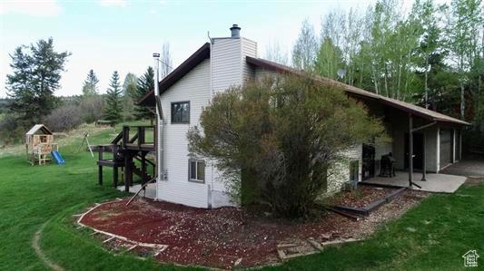 1204 Nashua Cir, Soda Springs, ID 83276 - view of property exterior with a patio area, a lawn, a playground, and a chimney