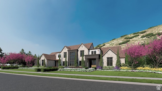 view of front of house with a front lawn, brick siding, and stone siding