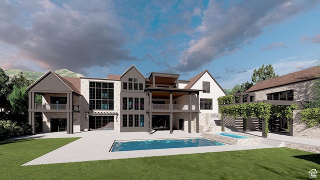 rear view of house with a balcony, a patio, a lawn, and an outdoor pool