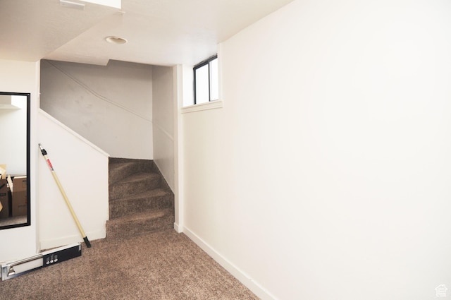 basement with carpet floors, stairway, and baseboards