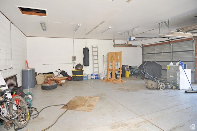 garage with a garage door opener and concrete block wall