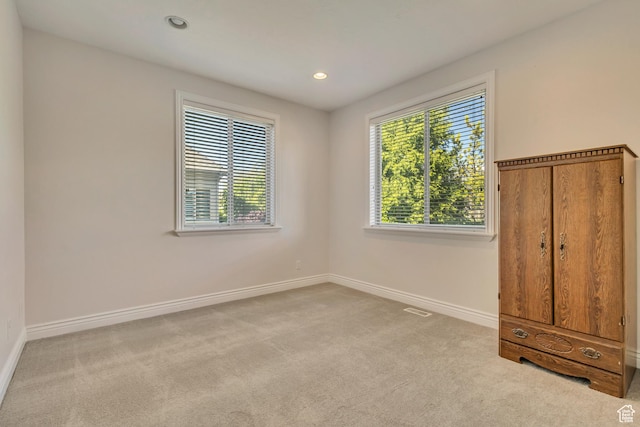 carpeted spare room featuring baseboards and recessed lighting
