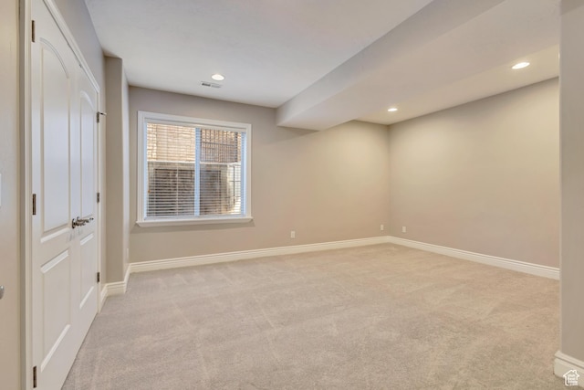 spare room with light colored carpet, baseboards, and recessed lighting