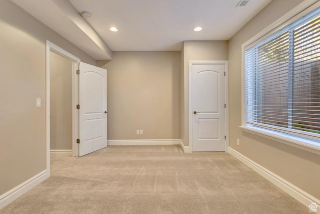 unfurnished bedroom with light carpet, recessed lighting, and baseboards