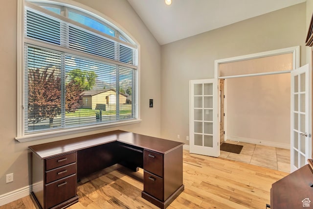 unfurnished office with french doors, light wood-style flooring, vaulted ceiling, and baseboards