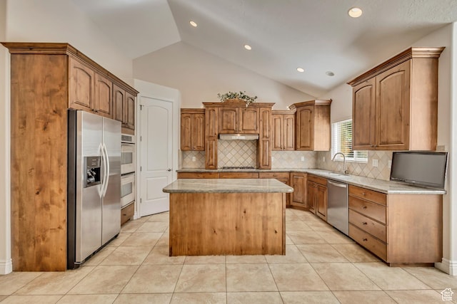 kitchen with appliances with stainless steel finishes, a sink, a kitchen island, decorative backsplash, and recessed lighting