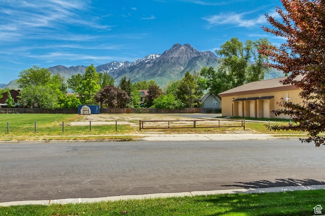 view of asphalt road featuring curbs and a mountain view