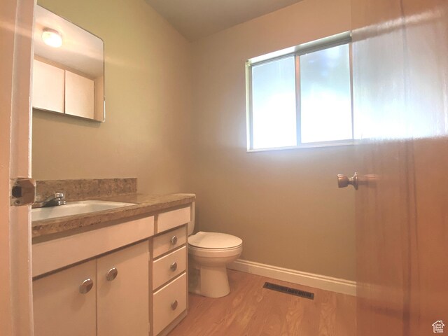 105 S 200 E, Richmond, UT 84333 - bathroom with wood finished floors, toilet, vanity, and baseboards