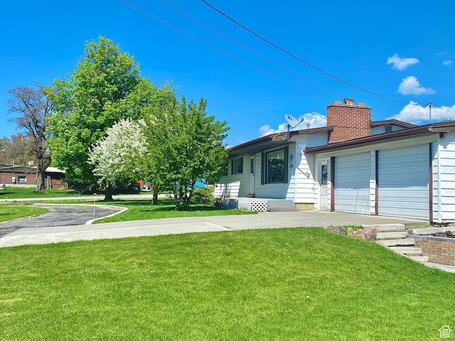 105 S 200 E, Richmond, UT 84333 - view of front of house featuring a front yard, a chimney, driveway, and an attached garage