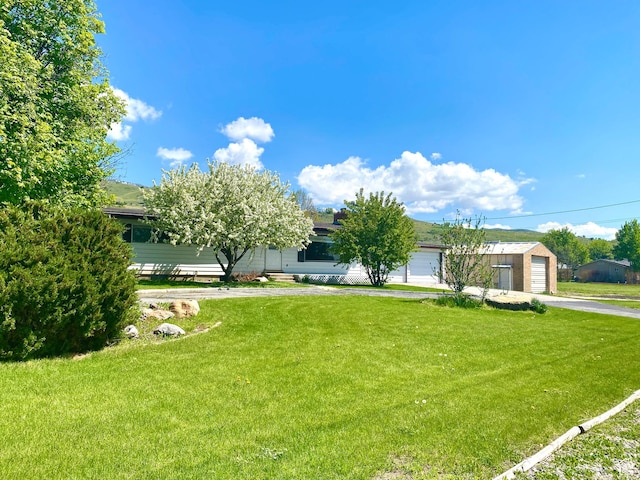105 S 200 E, Richmond, UT 84333 - view of front of home featuring a front yard, driveway, and an attached garage