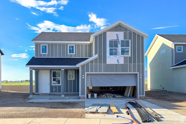 view of front of house featuring board and batten siding, concrete driveway, a shingled roof, an attached garage, and a porch