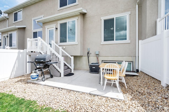 back of property with fence, stucco siding, and a patio