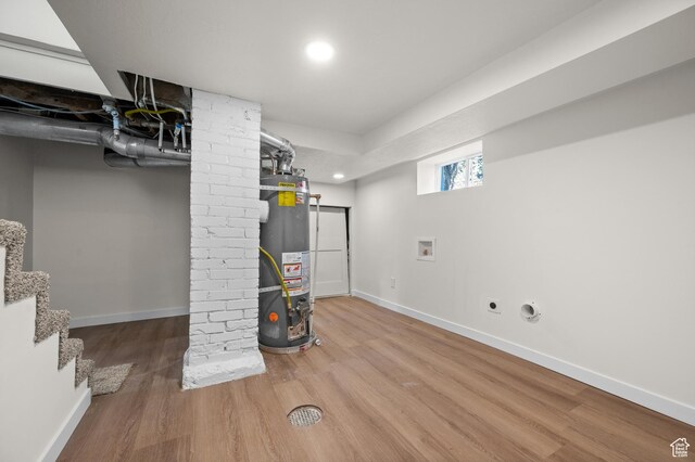 basement featuring secured water heater, wood finished floors, baseboards, and recessed lighting