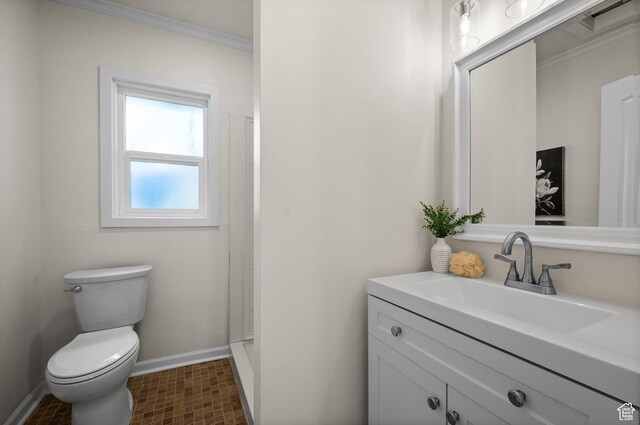 bathroom featuring baseboards, vanity, toilet, and crown molding