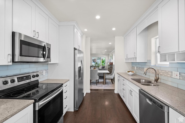 kitchen featuring stainless steel appliances, a sink, white cabinets, and recessed lighting