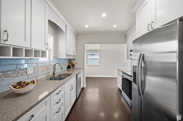kitchen featuring stainless steel appliances, a sink, baseboards, backsplash, and dark wood-style floors