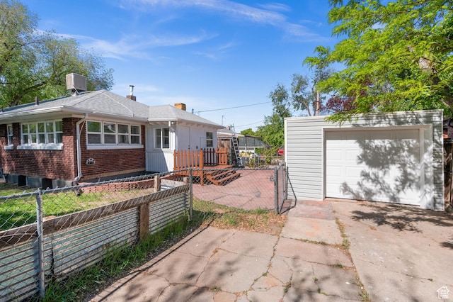 view of front facade with central air condition unit, fence, an outdoor structure, and concrete driveway