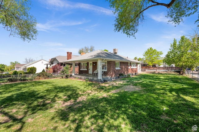 rear view of house featuring brick siding and a chimney