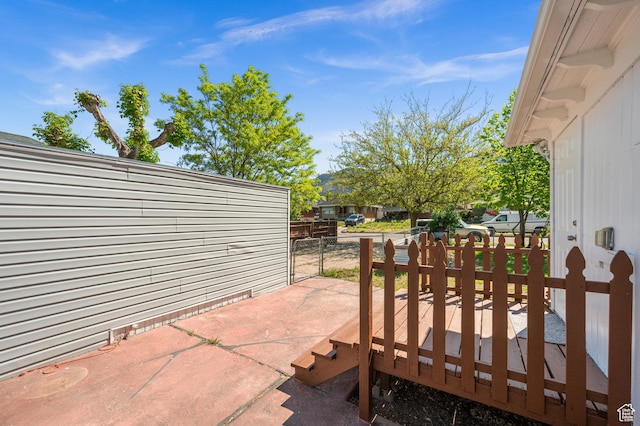view of patio featuring a deck and fence