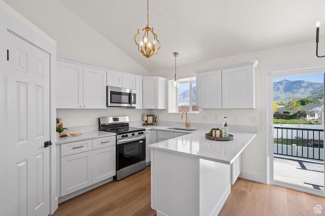 850 E Village Rd N, Ogden, UT 84404 - kitchen featuring appliances with stainless steel finishes, a sink, a peninsula, white cabinets, and lofted ceiling