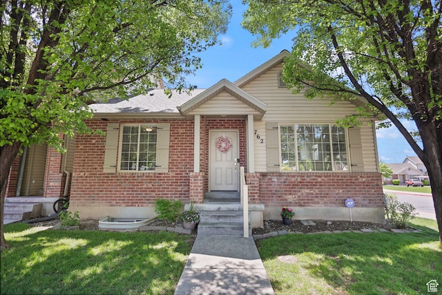 bungalow-style home featuring brick siding and a front yard