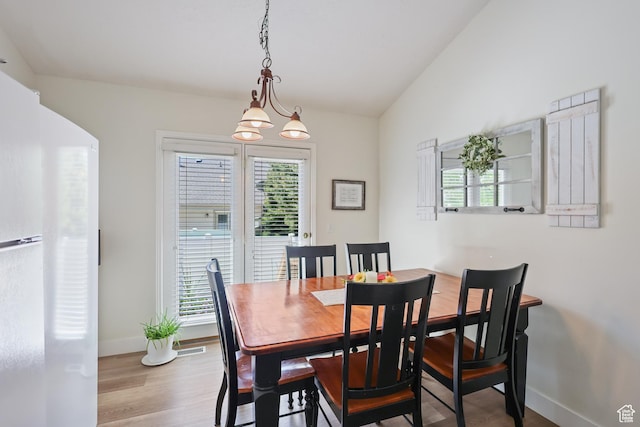 dining area with baseboards, wood finished floors, and lofted ceiling