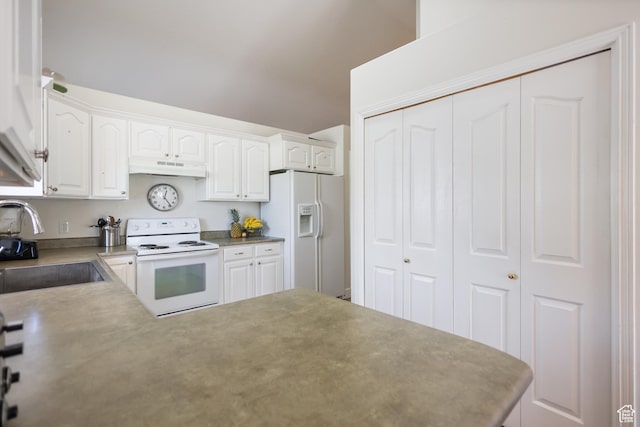 kitchen with white appliances, a sink, under cabinet range hood, white cabinets, and a peninsula