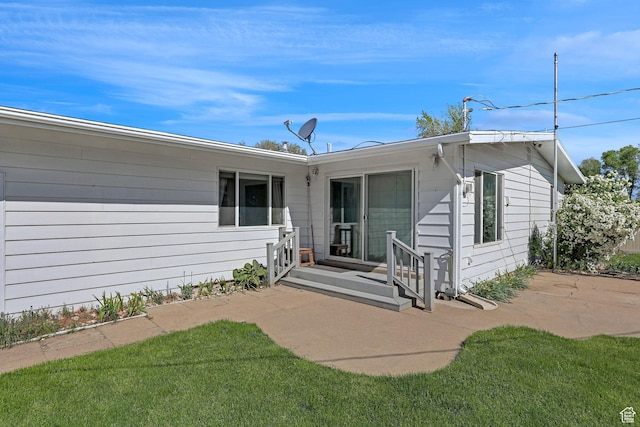 rear view of property featuring a patio and a yard