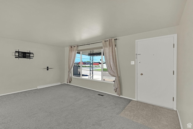foyer entrance featuring baseboards and carpet floors