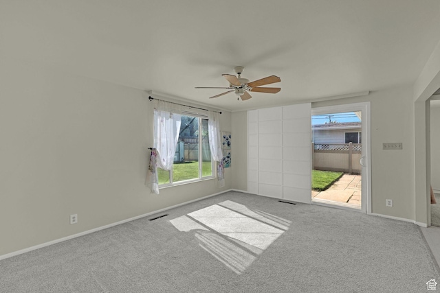 empty room featuring a ceiling fan, carpet, and baseboards