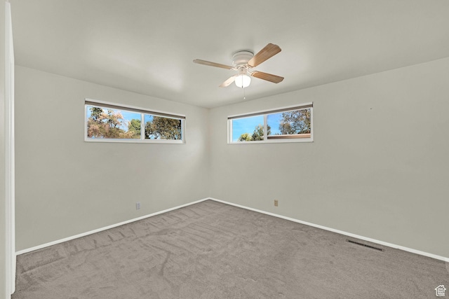 carpeted empty room featuring a ceiling fan and baseboards