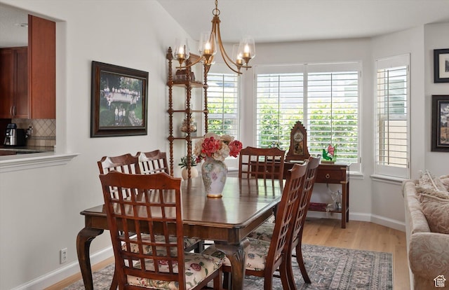 6721 S Costa Cv E, Cottonwood Heights, UT 84121 - dining room featuring light wood-type flooring, a chandelier, and baseboards