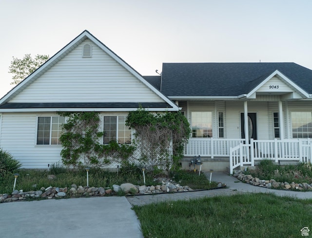 view of front of property with covered porch and a shingled roof