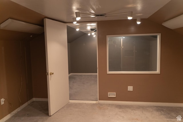 carpeted spare room with lofted ceiling and baseboards