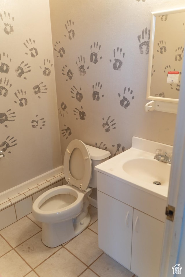 bathroom with toilet, tile patterned floors, and vanity