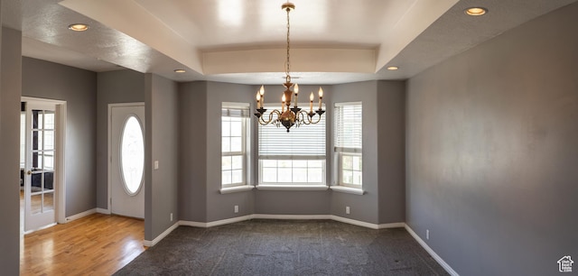 carpeted entryway with plenty of natural light, a chandelier, baseboards, recessed lighting, and a raised ceiling