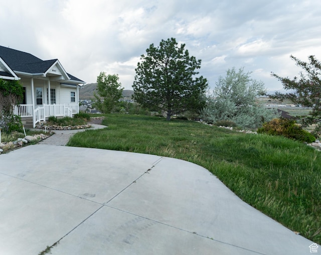 view of yard featuring a porch and a patio area
