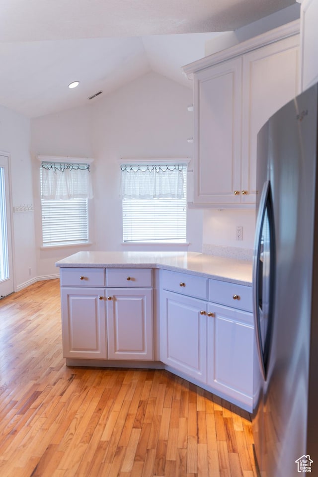 kitchen featuring freestanding refrigerator, white cabinets, light wood-type flooring, lofted ceiling, and recessed lighting