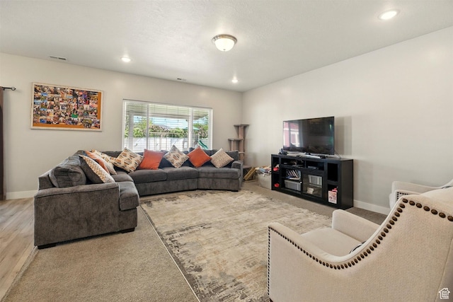 living room featuring baseboards, wood finished floors, and recessed lighting
