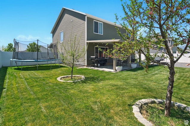 rear view of property with a trampoline and a patio